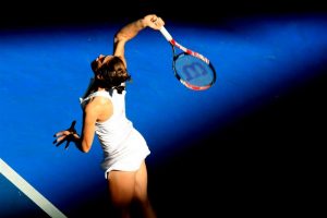 Andrea Petkovic serving just in the way of a beam of sunlight at Pat Rafter Arena